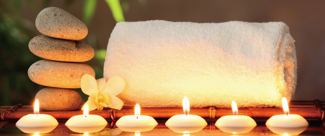 Towels, flowers and candlelight in a relaxing setting